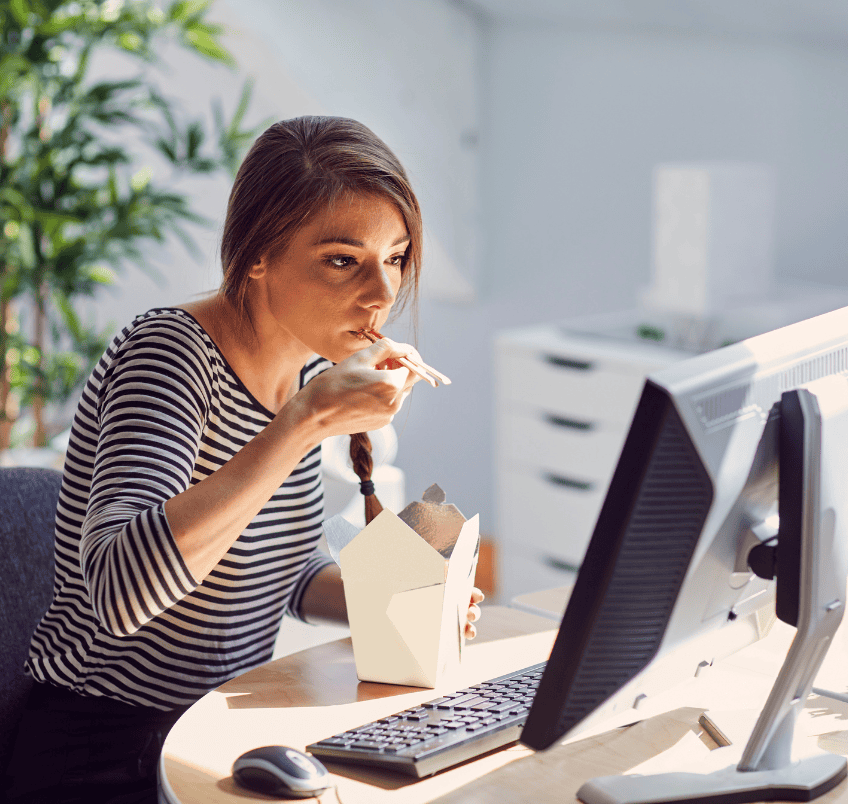 http://Woman%20eating%20at%20her%20office%20desk